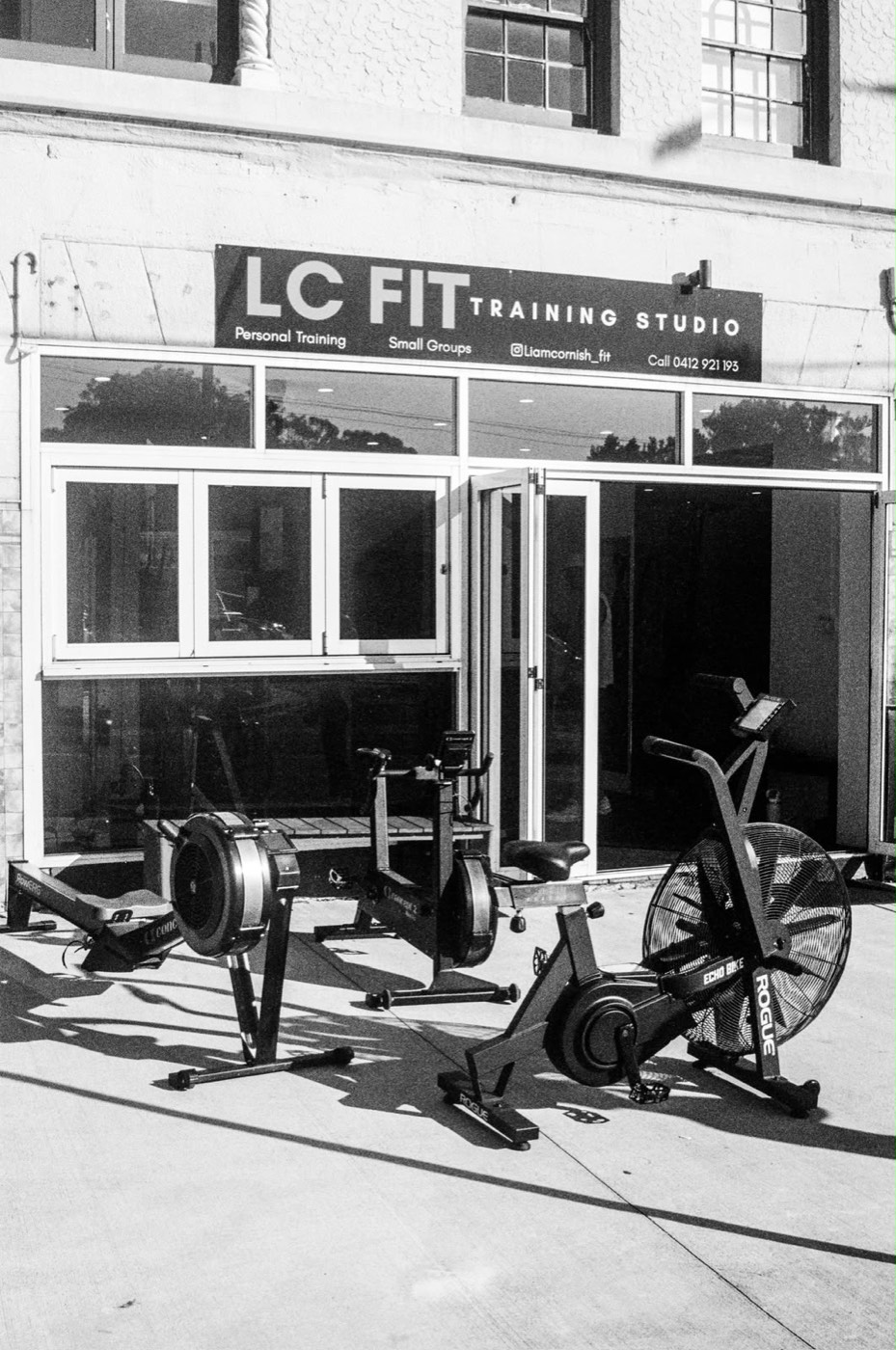 The LC FIT Training Studio storefront with the rower, bike and air bike lined up on the footpath
